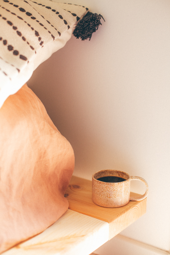 Tasse de café posée sur une tablette près d'un lit slow