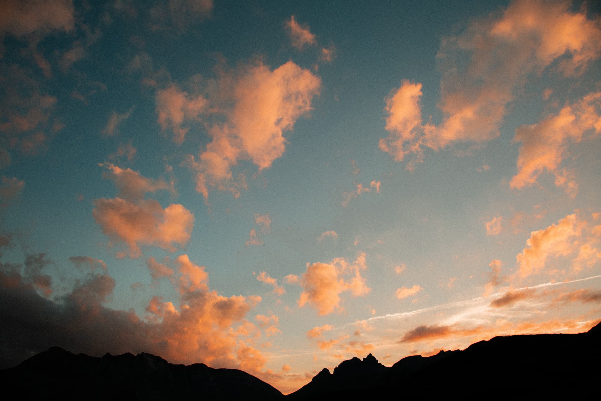 Nuages orangés au coucher du soleil au-dessus des montagnes
